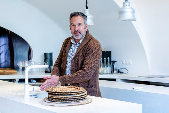 Mature man washing hands while standing at kitchen sink in home