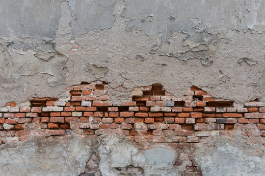 Alte Backsteinmauer mit abblätterndem Betong verputzt
