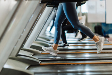 Male and female athlete exercising on treadmill in gym