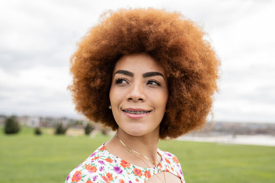 Smiling young woman looking away at park