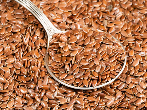 tablespoon in brown flax seeds close up