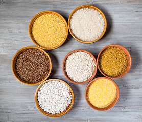 various raw groats in round ceramic bowls