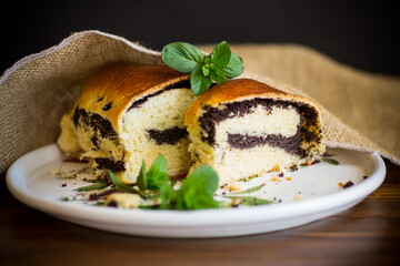 roll with poppy seeds inside on a wooden table.
