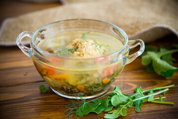 fresh hot soup with chicken meatballs and vegetables in a plate