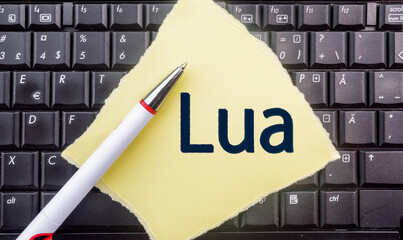 Lua Programming Language. Word Lua on paper and laptop
