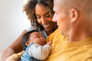 Happy parents smiling at their sleeping baby girl at home
