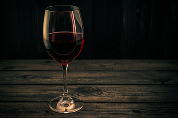Glass of red wine on an old wooden table