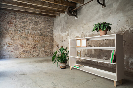 Fototapeta Wooden bookshelf standing in bare empty room