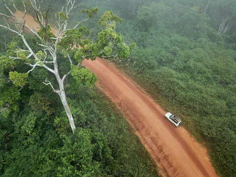 Gabon, Mikongo, Aerial view of 4x4 car parked on dirt road in middle of jungle