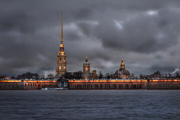 Obraz premium Evening city landscape, fortress on the river, against the background of the sky covered with clouds