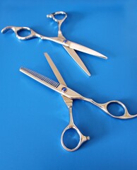 Professional hairdressing scissors, hairdressing tools, blue background, scissors for cutting and filing hair