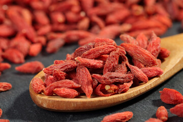Extreme close up of dried Goji Berries (Wolfberry) in a wooden spoon. Macro superfood with...