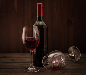 Bottle of red wine with two glasses on an old wooden table