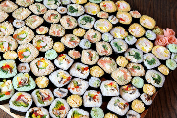 Sushi Set - Different Types of Maki Sushi and Nigiri Sushi. Served on dark wooden table.