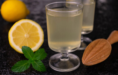 Fototapeta premium Liqueur limoncelo in a glass on a black background. Close-up.
