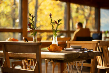 Wildflower bouquet and autumn gourds on rustic cafe table