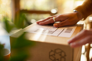 Close up business owner placing shipping label on package