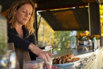 Female food cart owner arranging pastries