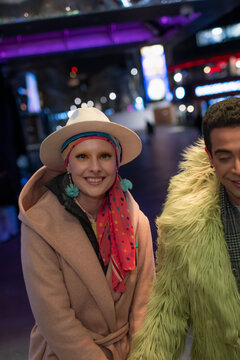 Portrait happy stylish couple on city street at night