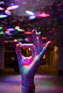 Close up woman gesturing okay with hand under neon lights