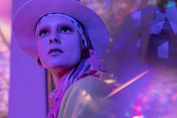 Portrait beautiful fashionable woman in fedora under neon lighting