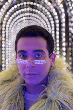 Portrait stylish young man in pear glasses under arch lights