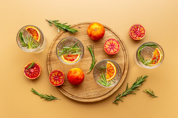 Glasses of cold drink with red oranges and rosemary