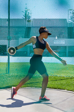 Female track and field athlete throwing discus