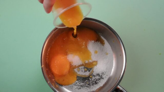 The pastry chef prepares the cream for the cake. Mixing eggs and sugar in a saucepan. 