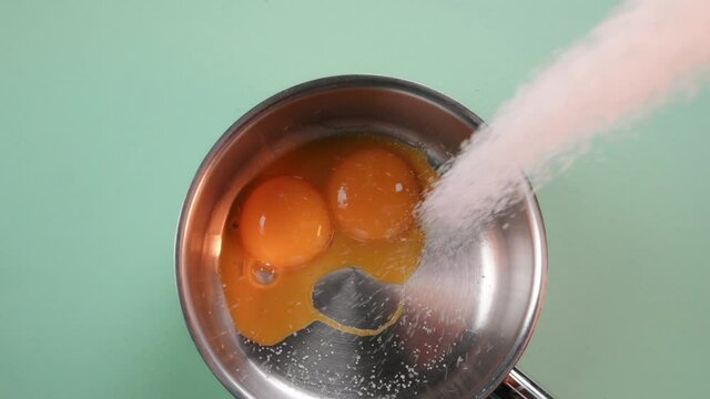 Pastry chef adds sugar to the yolks. Process of making cream for dessert. Dessert preparation process. 