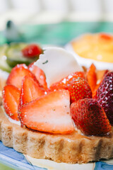 strawberry tartlet with other types of tartlets in the background