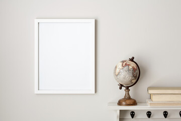11x14 thin white vertical frame mockup hanging on a neutral coloured wall, next to a white shelf...