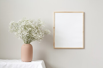 16x20 empty thin wood vertical frame minimalist mockup template. With terra cotta vase and flowers.