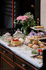cakes on the tables and beautiful pink chrysanthemums in a vase. festive table