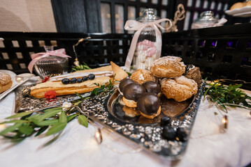 buffet table with profiteroles in chocolate and cakes with cream