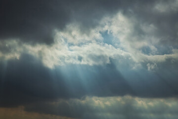 RAY OF SUNLIGHT ESCAPING AMONG THE CLOUDS . Sky with sun rays among the clouds . the rays of the sun among the clouds of the sky .