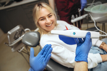 The dentist scans the jaw and creates a 3D model on the computer for the manufacture of a denture. Smiling patient woman