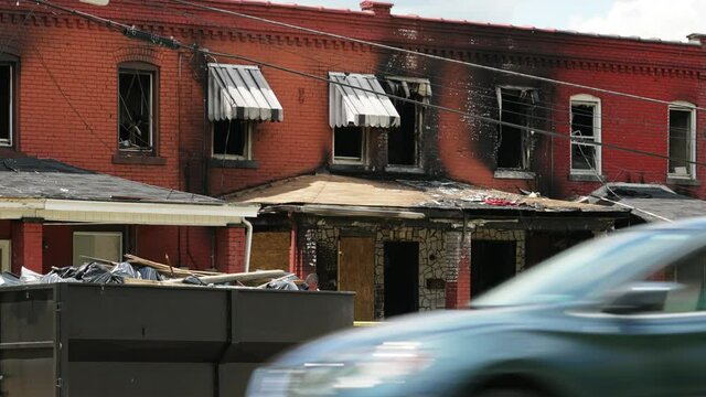 Traffic passes in front of red brick row houses that recently caught fire. Pittsburgh suburbs.  	