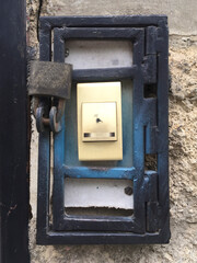Fototapeta na wymiar Door Bell with a Small Grille and a Padlock