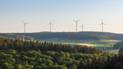 Wind turbines at the horizon in green rural landscape in Werbach, Germany.  Alternative renewable...