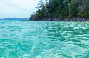 Soft blue ocean wave on clean sandy beach
