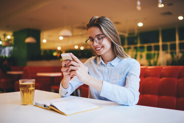 Cheerful woman browsing phone during rest