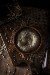 Rice in a wooden cup on a rustic table