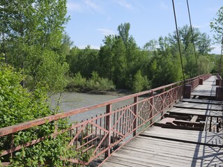 narrow damaged bridge over mountain river