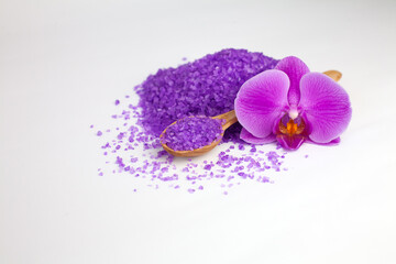 Fototapeta na wymiar Purple sea salt and purple orchid on white background. Spa treatments. Beauty and health concept. Close-up.