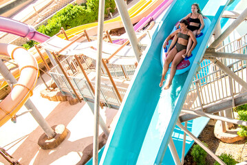 Two cute teenage girls in water Park. Fun on the water. Teen girl and boy having fun in the water...