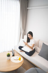 asian woman using mobile phone at home Communication and coziness concept.
