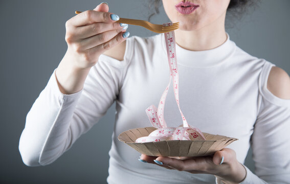 a young girl eats a meter with a fork. deit concept