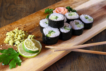 Sushi Set - Different Types of Maki Sushi and Nigiri Sushi. Served on dark wooden table.