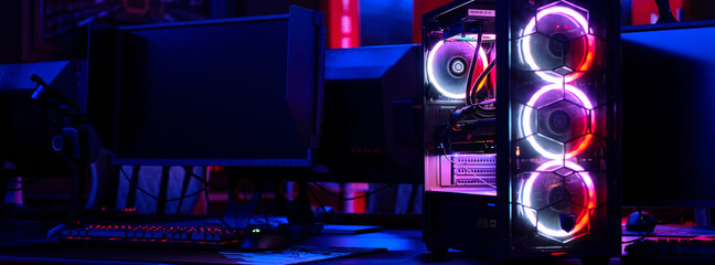 Top-end system unit for gaming computer close up. Inside of illuminated cybercafe. Concept of...